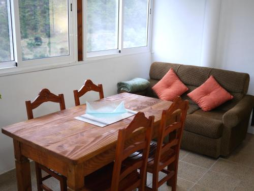a dining room table with chairs and a couch at Green Valley Cruzinhas House with Fireplace & BBQ in Santana