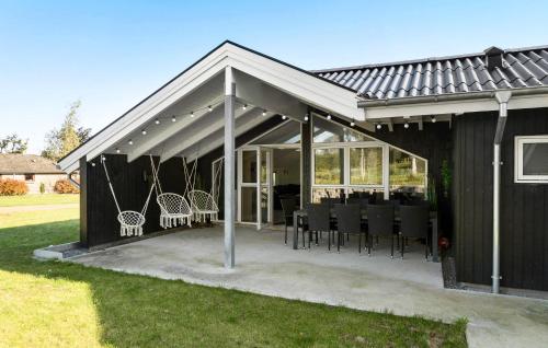 patio riparato con sedie nere e tavolo di 5 Bedroom Cozy Home In Hejls a Hejls