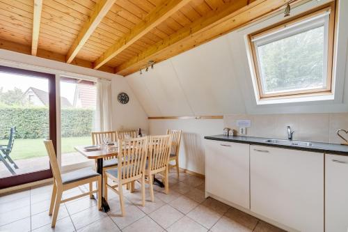 a kitchen and dining room with a table and chairs at Roerdomp I Vrijstaande Bungalow met Buiten Zitjes in Zwiggelte