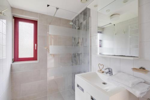 a white bathroom with a sink and a mirror at Roerdomp I Vrijstaande Bungalow met Buiten Zitjes in Zwiggelte