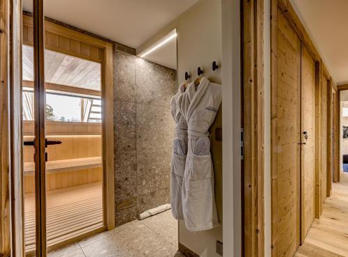 La salle de bains est pourvue d'une douche et d'un peignoir accroché au mur. dans l'établissement Chalet Josephine, Chamonix Les Bois, à Chamonix-Mont-Blanc