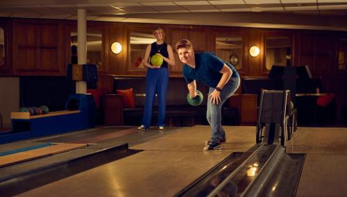 two men playing bowling in a bowling alley at WestCord Strandhotel Seeduyn in Oost-Vlieland