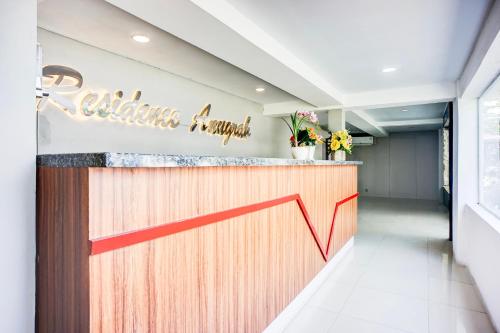 メダンにあるHotel O Medan City Near Sun Plaza Formerly Residence Anugrahの花の咲くカウンターのレストランのバー