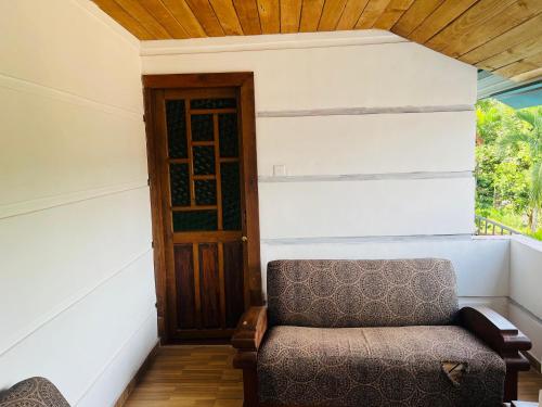 a room with a chair and a door at Nisala Rest in Gampola