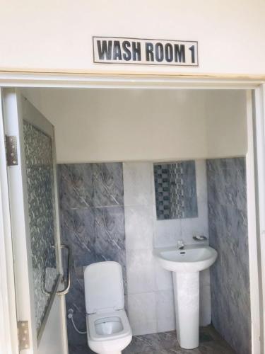 a bathroom with a sink and a toilet and a wash room at Sunstar Nilaveli in Trincomalee