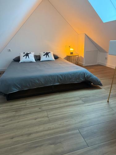 une chambre avec un grand lit dans un grenier dans l'établissement Maison cosy au cœur d'Étaples sur mer, à Étaples