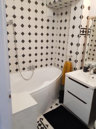 a bathroom with a white tub and a sink at Kussbach apartman in Sárospatak