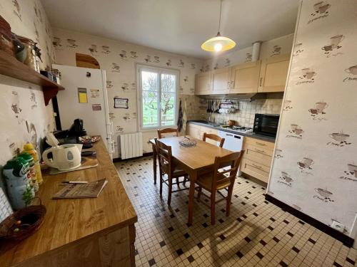 a kitchen with a wooden table and a dining room at Gite - La Boutardière in Rilly-sur-Loire