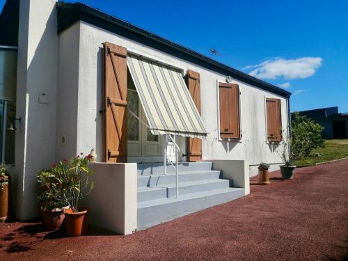 a white house with stairs and a door and a porch at Gite - La Boutardière in Rilly-sur-Loire
