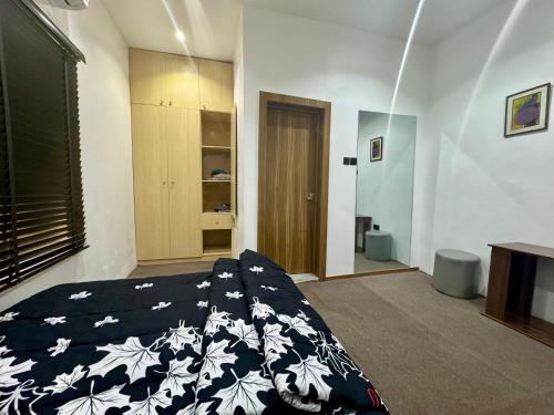 a bedroom with a bed with a black and white blanket at House 12 Two-Bed Studio Apartment in Ilorin