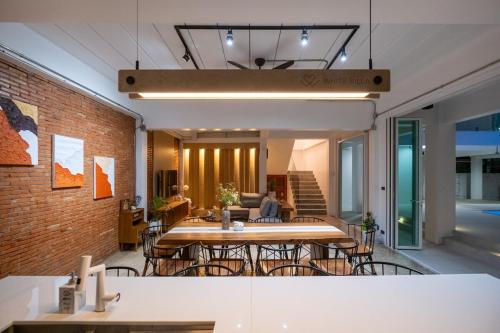 a room with tables and chairs and a brick wall at White Pool Villa Chiangmai in Chiang Mai
