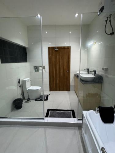 a bathroom with a shower and a toilet and a sink at House 12 Two-Bed Studio Apartment in Ilorin