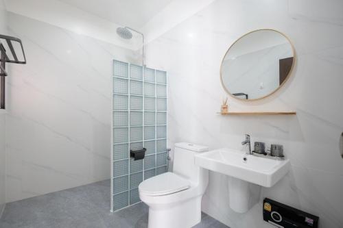 une salle de bains avec toilettes, lavabo et miroir dans l'établissement White Pool Villa Chiangmai, à Chiang Mai