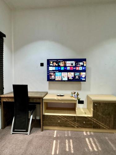 a desk with a television on a wall at House 12 Two-Bed Studio Apartment in Ilorin