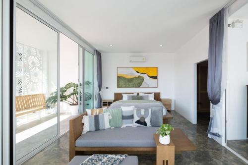 une chambre avec un lit et un canapé dans l'établissement White Pool Villa Chiangmai, à Chiang Mai