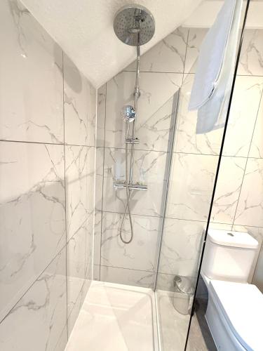 a shower with a glass door and a toilet at The Loft Apartments Cardiff Central in Cardiff