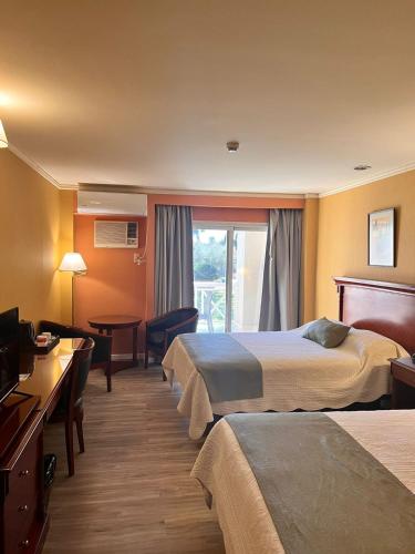 a hotel room with two beds and a balcony at Condado Hotel Casino Santo Tome in Santo Tomé