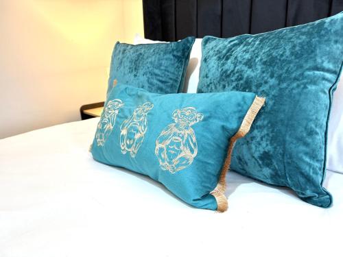 a pair of blue pillows on a bed at The Loft Apartments Cardiff Central in Cardiff
