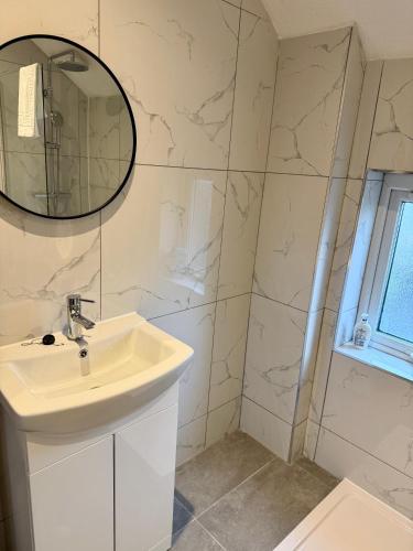 a bathroom with a sink and a mirror at The Loft Apartments Cardiff Central in Cardiff
