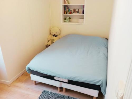 a teddy bear sitting on a bed in a bedroom at L 'Échappée Marine au coeur de Concarneau in Concarneau