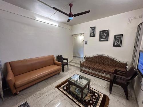 a living room with a couch and a table at HOLIDAYFUNDA's Homestay - Baga Bungalow in Panchgani