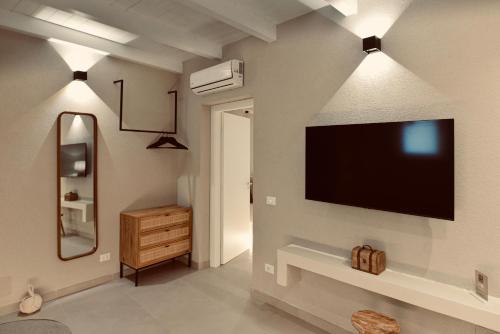 a living room with a flat screen tv on a wall at Palermo Inn Boutique Hotel in Palermo