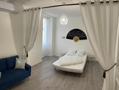 une chambre avec un lit et un canapé bleu dans l'établissement Appartement duplex plein cœur village, à Sérignan