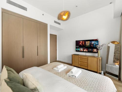 a bedroom with a bed and a tv on the wall at The Chic Downtown Suite Luxury near Burj Khalifa in Dubai