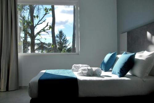 a bedroom with a bed with blue pillows and a window at Tiber Suite in Rome