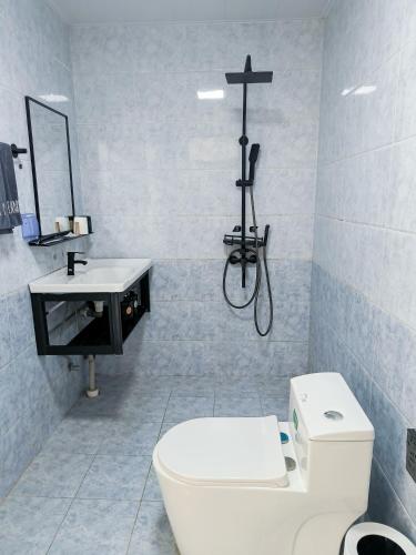 a bathroom with a toilet and a cross on the wall at Prajna Pavilion in Dali Ancient Town