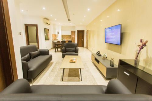 a living room with two couches and a tv at Accra Luxury Apartments at Avant Garde in Accra