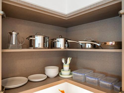 a kitchen with pots and pans on a shelf at The Chic Downtown Suite Luxury near Burj Khalifa in Dubai
