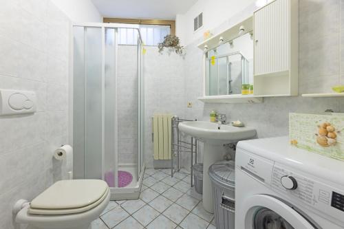 un bagno con un water, un lavandino e una lavatrice di Casa Anna a Pomonte - Goelba a Pomonte