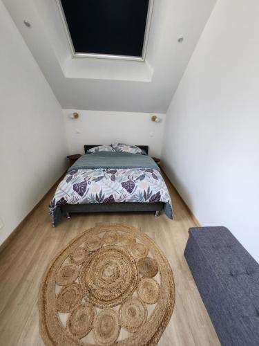 a bedroom with a bed and a rug at Jolie longère près Canal Nantes-Brest ' Pétanque in Guenrouet