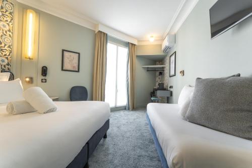 a hotel room with two beds and a window at ELSA, Hôtel Paris in Paris
