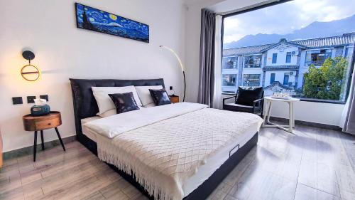 a bedroom with a large bed and a large window at Prajna Pavilion in Dali Ancient Town