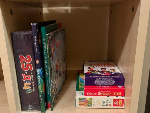 a group of books sitting on a shelf at Aspen Suites Студио Слънчев ден in Razlog