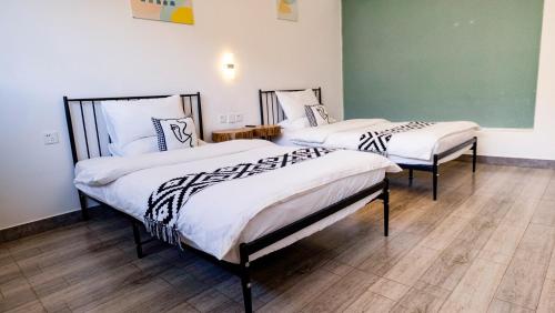 two beds in a room with white and black sheets at Prajna Pavilion in Dali Ancient Town