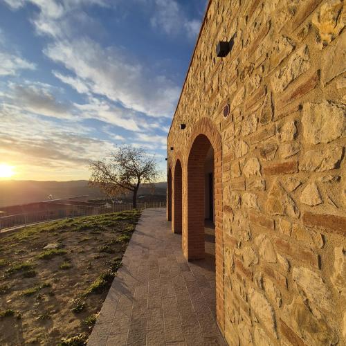 a stone wall with a pathway next to a building at Agriturismo Giorgini in Marsciano