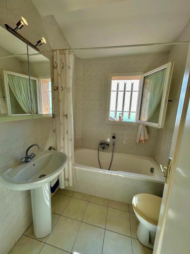 une salle de bain avec un lavabo, une baignoire et des toilettes dans l'établissement Villa Aurelle vue mer, à Saint-Raphaël