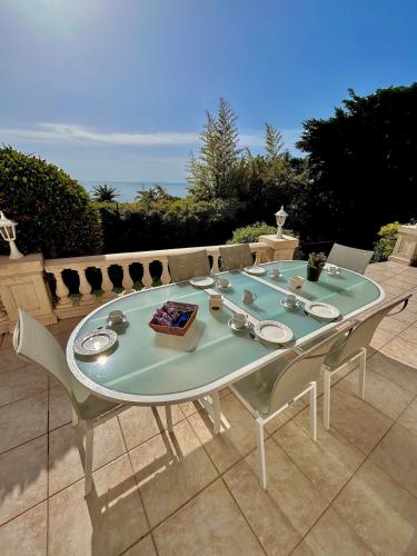 une table blanche et des chaises sur une terrasse dans l'établissement Villa Aurelle vue mer, à Saint-Raphaël