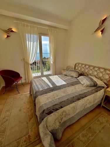 une chambre avec un lit et une grande fenêtre dans l'établissement Villa Aurelle vue mer, à Saint-Raphaël