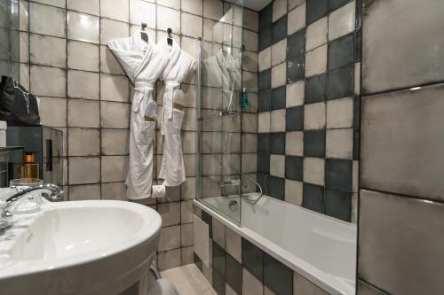 a bathroom with a sink and a bath tub and a sink at ELSA, Hôtel Paris in Paris