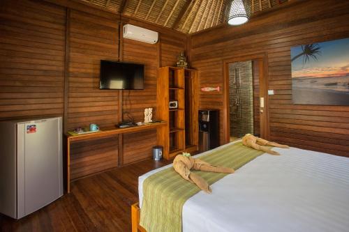 ein Schlafzimmer mit einem Bett mit zwei Tierköpfen darauf in der Unterkunft Gecko Villa & Bungalows in Nusa Lembongan