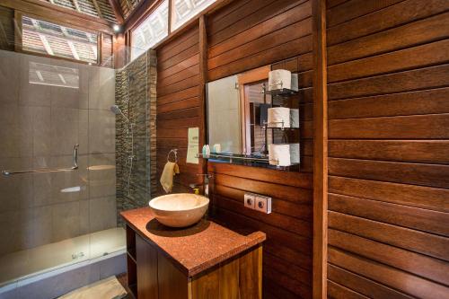 ein Bad mit einem Waschbecken und einer Dusche in der Unterkunft Gecko Villa & Bungalows in Nusa Lembongan