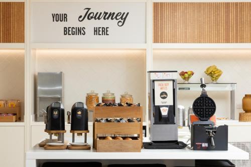 a coffee shop with a counter with various items on it at Hampton by Hilton London Gatwick Airport in Horley