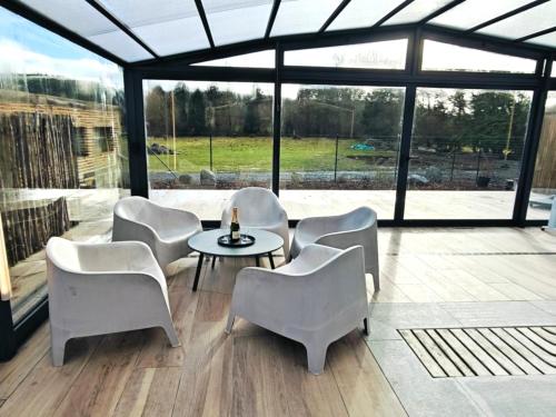 a living room with a table and chairs and a large window at Château-ferme de Pondrome in Beauraing