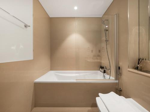 a bathroom with a bath tub and a toilet at The Chic Downtown Suite Luxury near Burj Khalifa in Dubai
