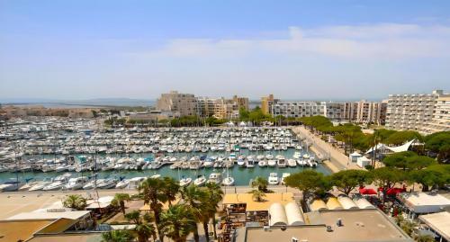 a marina with boats in the water and buildings at Le Bella Vista Vue Port Carnon Proche Plage in Mauguio
