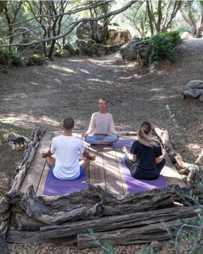a group of three people sitting in a yoga pose at Gallicantu Stazzo Retreat in Luogosanto